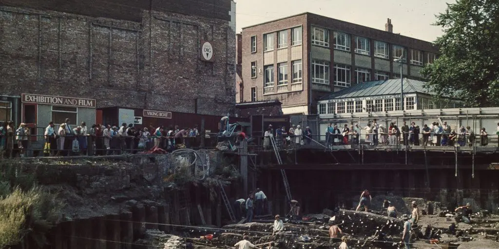 Archaeologists excavating the Coppergate site in York in 1978, with a crowd of spectators watching from above.
